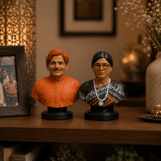 Two busts of a man and a woman on a wooden surface with a blurred background